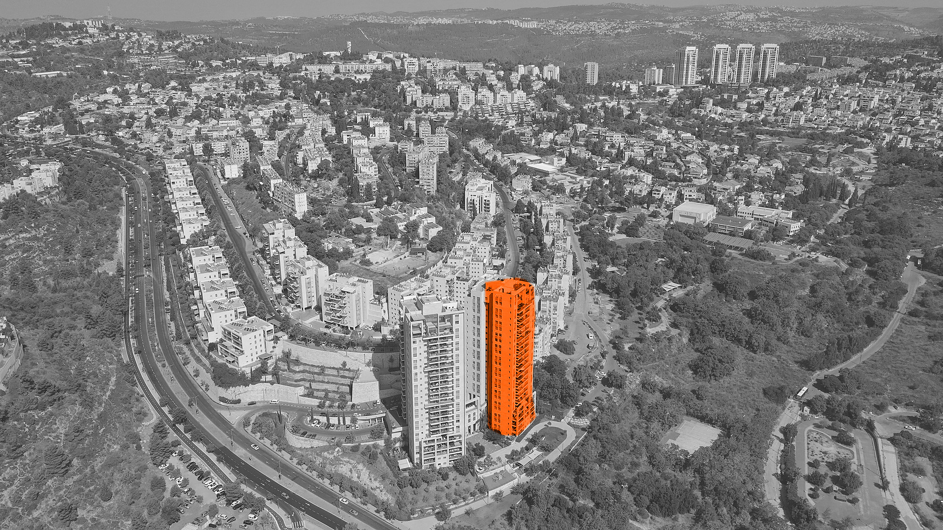 Black-and-white aerial view of apartment blocks in Kiryat Menachem and Kiryat Yovel, Jerusalem, with one residential tower highlighted in orange